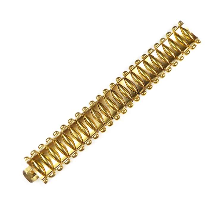 Gold articulated strap bracelet, alternating torpedo and convex baton shaped links forming a unified band